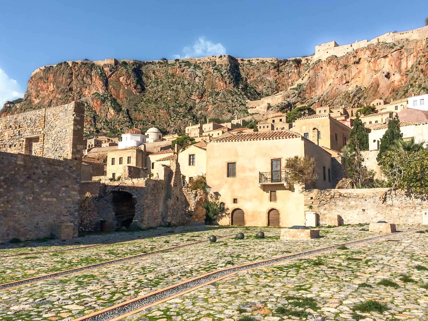 sandstone coloured houses against a mountain in Monemvasia on the peloponnese