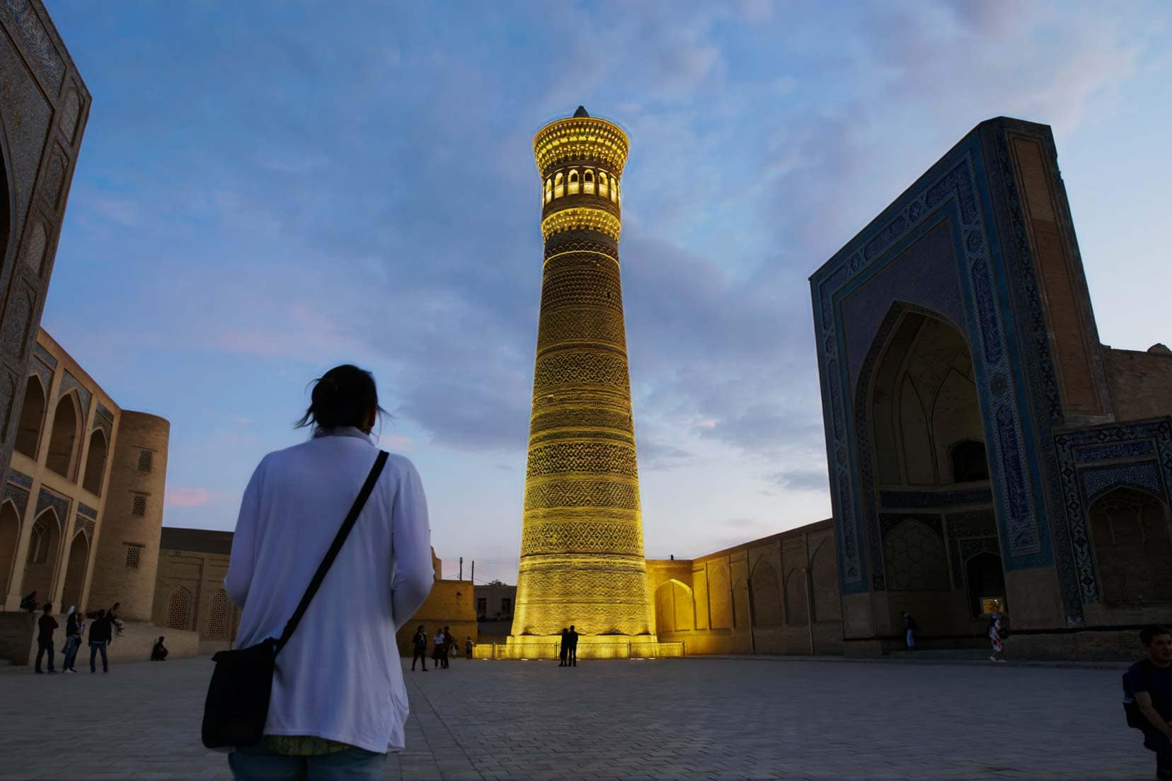 Shelley-wearing-black-pacsafe-handbag in Uzbekistan looking at a lit up tower 