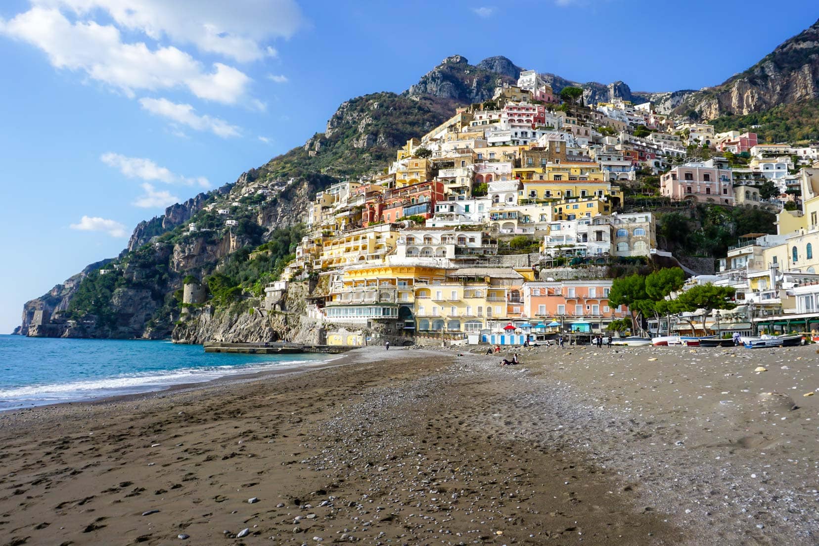 Positano with coloured houses on a steep cliff face and beach in the foreground