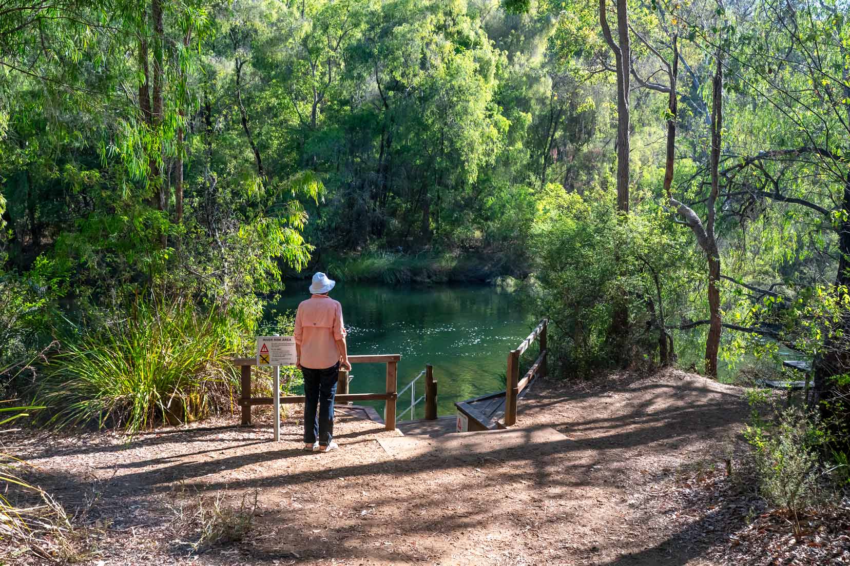 Long Pool seen through the trees with shelley stood near the steps into the water 