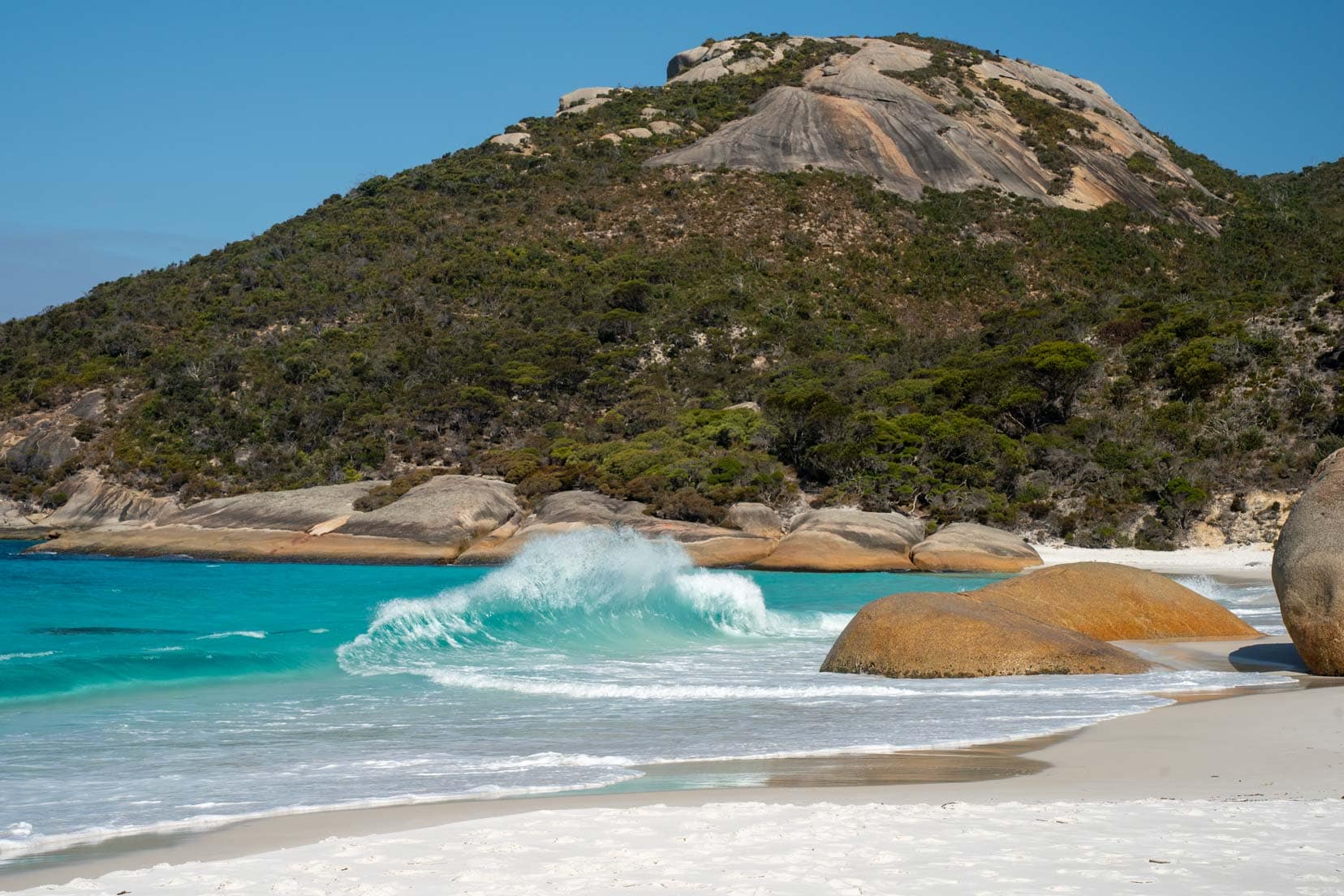 Little Beach, Albany - a white sandy beach with a couple of smooth granite rocks on the shore and surrounded by green hills