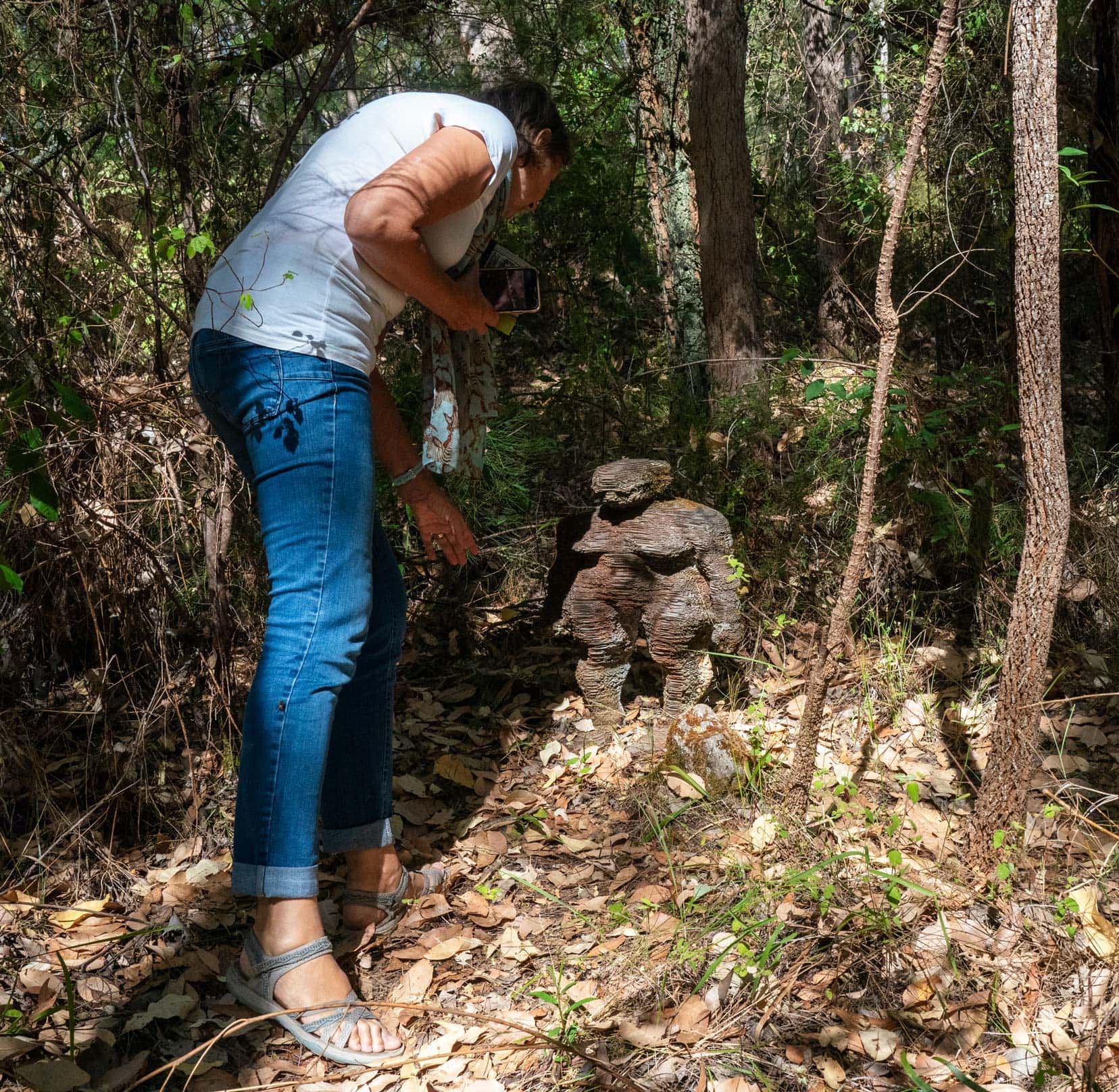 shelley leaning over one of the Forest folk scuptures which is about an arms length height