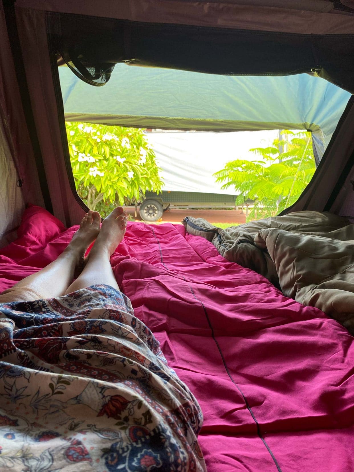 Shelley laying on top of the sleeping bags in the roof top tent  