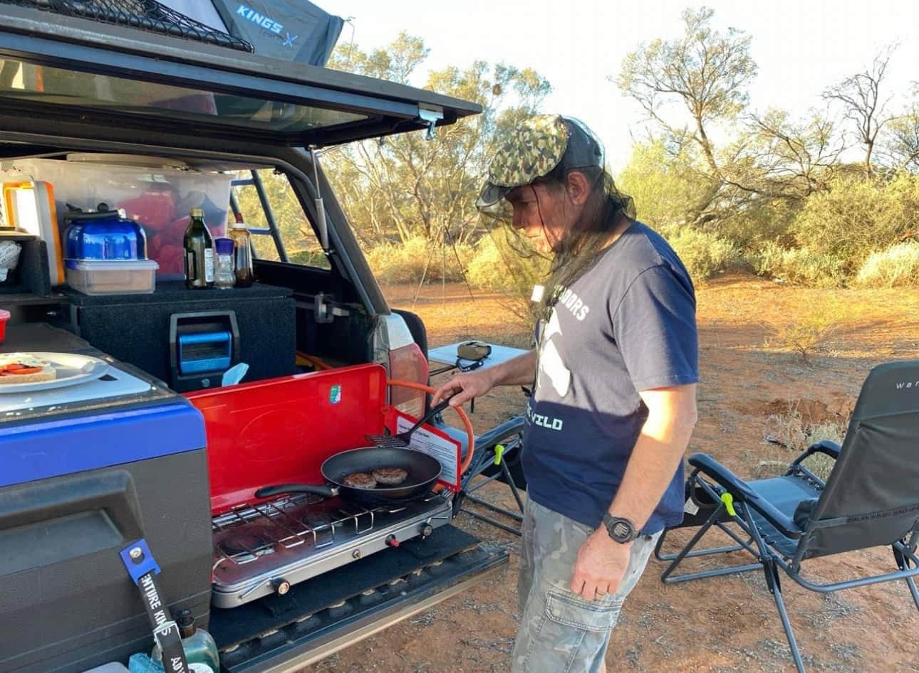 Camping in WA Lars cooking on our portable gas stove at the back of the car 