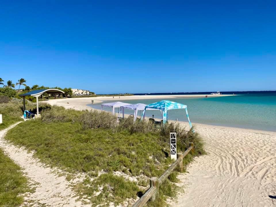 Camping in Western Australia Coral Bay sandy beach with shade cabanas on the beach 